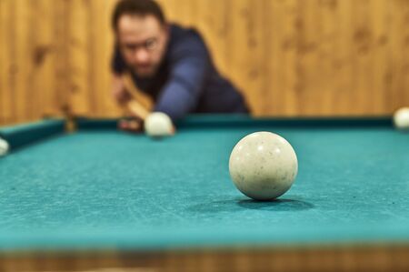 Middle-aged man playing billiards in the club.