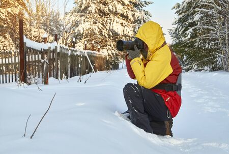 Photographer taking pictures in village in cold winterの写真素材