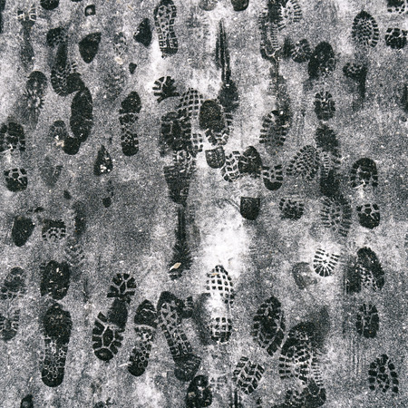 Footprints of the people in the snow on asphalt in winter after snowfallの写真素材