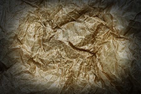 Background of old crumpled yellow greasy paper with a vignetteの写真素材
