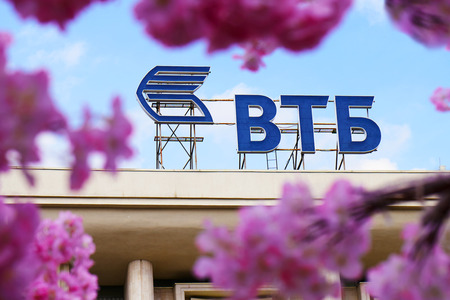 Russia, Moscow - April 30, 2018. VTB bank logo seen through the flowers of a decorative cherry tree on Moscow streetのeditorial素材