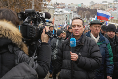 Moscow, Russia - February 24, 2019. Nemtsov memorial march. Foreign journalist with a microphone is reporting from the scene to the digital cameraのeditorial素材