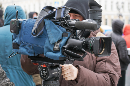 Moscow, Russia - February 24, 2019. Nemtsov memorial march. Cameraman with his camera packed in case on Moscow street in winterのeditorial素材
