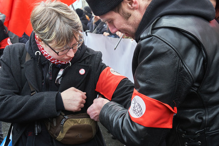 Moscow, Russia - March 10, 2019.Political rally for a free Internet. National Bolshevik ties a red armband with the emblem of the party on the girls armのeditorial素材