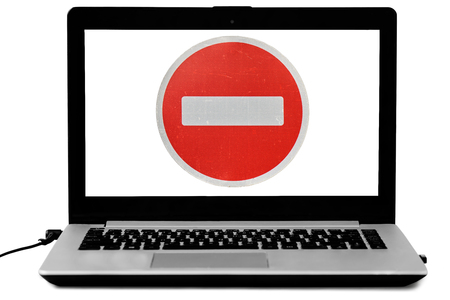 Laptop with a do not enter road sign on the screen isolated on white. Denied access concept.の写真素材
