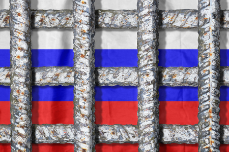 Symbol of oppression of freedom in Russia. Crossing metal bars of the prison grate on the background of the Russian flagの写真素材