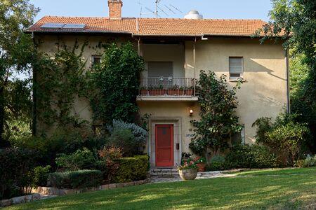 Beautiful villa surrounded by trees and flowers on the green meadow in Israelの写真素材