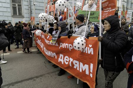 Moscow, Russia - February 29, 2020. People carrying russian flags and banners with photos of Boris...