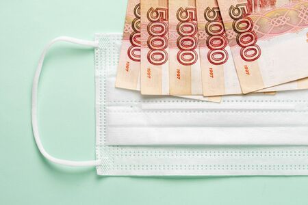 Medical mask with Russian money lying on it. The concept of increasing prices for medical masks in...