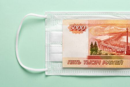 Medical mask with Russian money lying on it. The concept of increasing prices for medical masks in...
