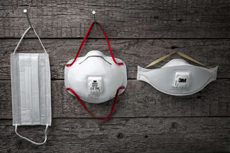 Moscow,Russia-April 24,2020.Personal protective equipment like respirators and medical mask hang on nails put into the rough wooden wallのeditorial素材