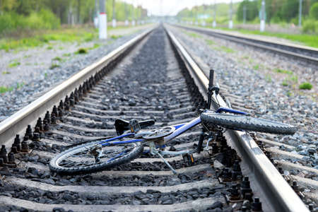 Accident with a bicycle in railway road. Broken bicycle lying between railroad rails.の写真素材