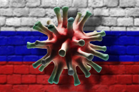 Coronavirus cell on the brick wall painted in russian flag colors background with shadows. A pandemic of coronavirus in Russia conceptの写真素材