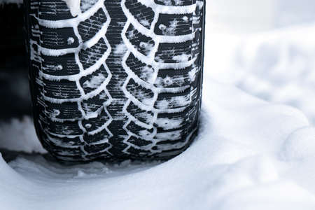 Winter studded tire tread standing in the snow close upの写真素材
