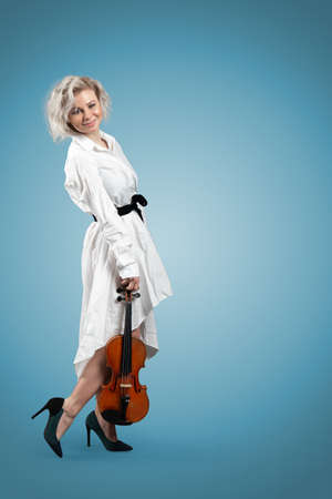 Young blonde woman posing with a violin her handの写真素材