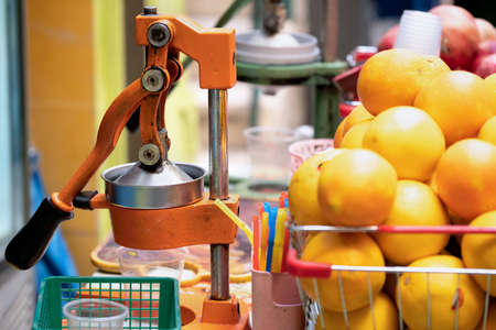 Juicer with a lot of ripe oranges outdoors on the street market in Jerusalem, Israel close upの写真素材