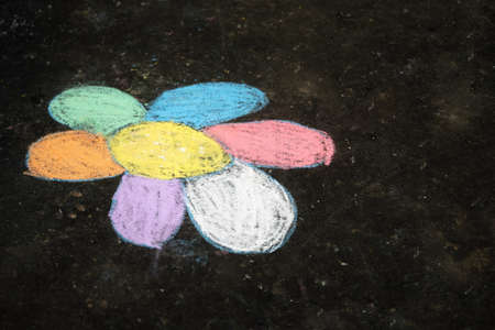 Childrens chalk drawing of a flower on the asphaltの写真素材