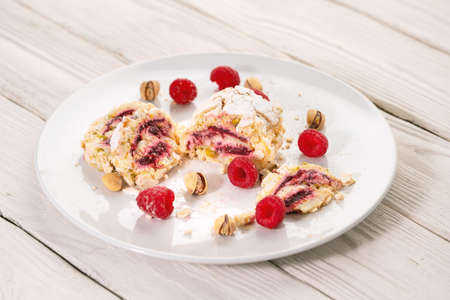 Tasty sweet roll cake with pistachios and raspberry on the plateの写真素材