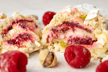 Close up of a sliced pistachio roll with fresh raspberriesの写真素材