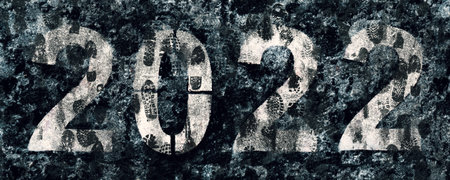 Numbers 2022 painted on asphalt covered with dirty footprints on melted snow