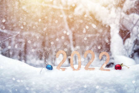 2022 plywood new year numbers in a snowdrift outdoors with Christmas balls