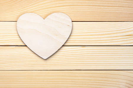 Plywood heart lies on the wooden boardsの写真素材