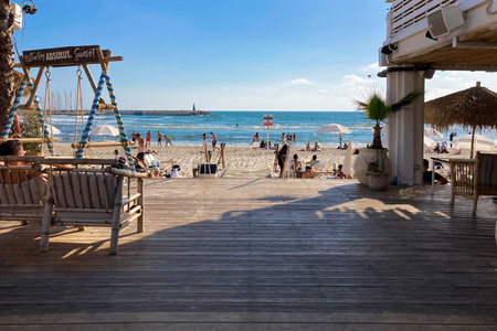 Tel Aviv,Israel - MAY 15, 2022: Outdoor beach restaurant with people resting on the beachのeditorial素材