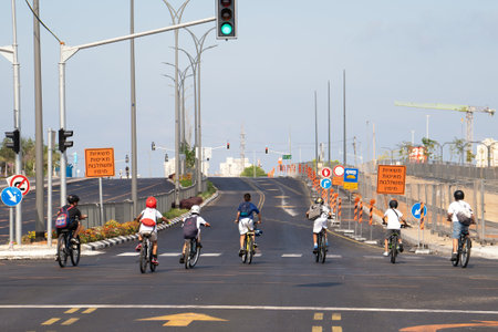 Rishon Lezion, Israel - September 25, 2023: Kids ride on bicycles along a highway empty of cars during the holiday of Yom Kippurのeditorial素材