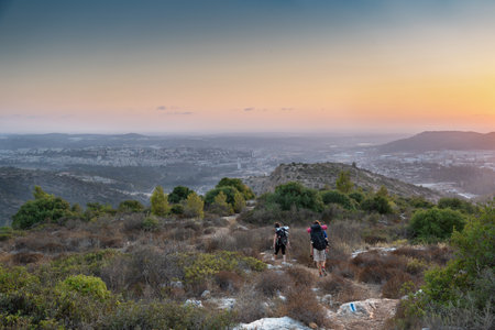 Israeli mountain landscape near Beit Shemesh town with couple of hikers in sunsetの写真素材