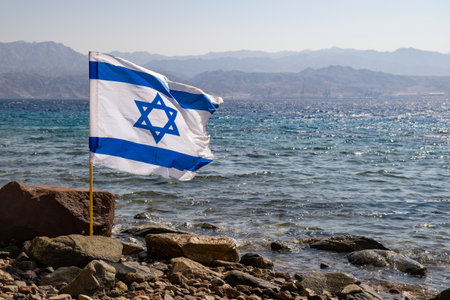 Israeli flag on Red sea with Jordanian mountains on the backgroundの写真素材