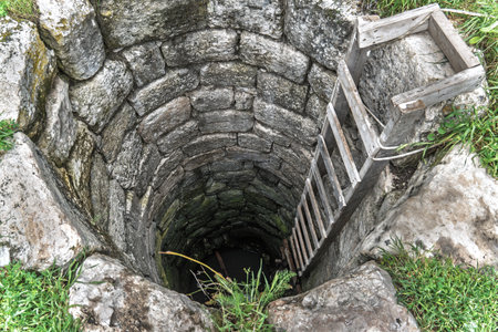 Old Stone Water Well with Wooden Ladderの写真素材