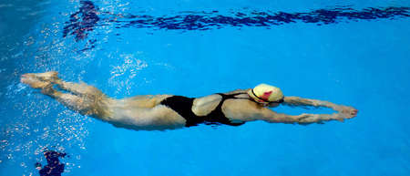 Young female swimmer under the waterの写真素材