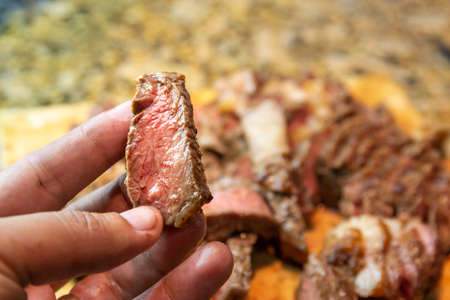 Hand holding a delicious piece of rib eyeの写真素材