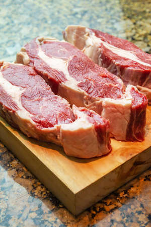 3 raw ribeye on a wooden board white backgroundの写真素材