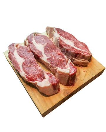 3 raw ribeye on a wooden board white backgroundの写真素材