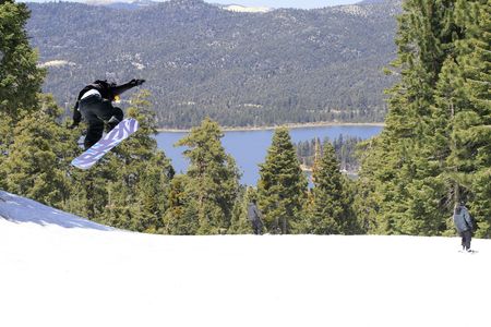 Winter. Lake view in Mountains. Snowboarder jumping high in the airの写真素材