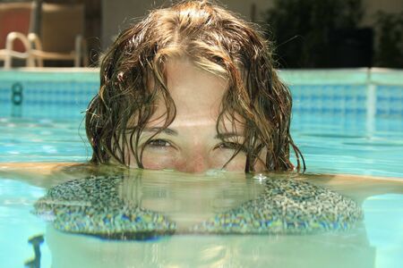 Girl having fun in an outdoor swiming pool