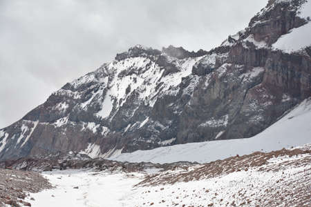 A mountain range surrounded by clouds and shadowsの写真素材