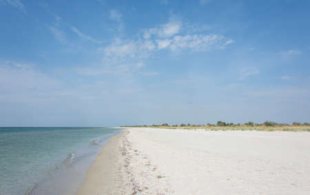 Deserted, uninhabited, wild beach by the sea or the ocean on a sunny dayの写真素材