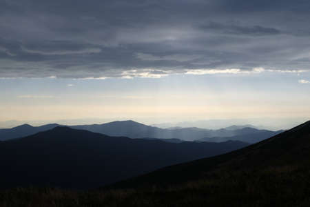Endless mountain range under a thundercloud in anticipation of a storm and weatherの写真素材