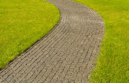 paving stone of large granite winds among green lawnsの写真素材