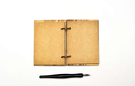 an open notebook with a cover made of natural materials and an old fountain pen