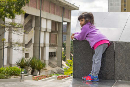 Cute thoughtful girl on a wallの写真素材