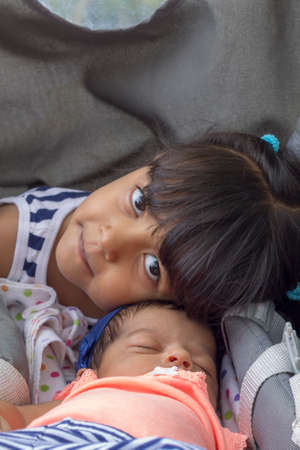 Cute sisters hugging tenderly and demonstrating a lot of love