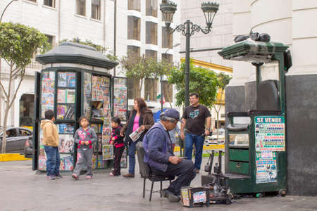 LIMA, PERU - AUG 29TH 2015: Man dedicated to the informal economy in the streets of downtown Lima, is dedicated to polishing shoes for peopleのeditorial素材