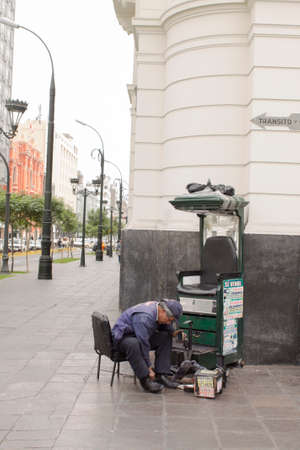LIMA, PERU - AUG 29TH 2015: Man dedicated to the informal economy in the streets of downtown Lima, is dedicated to polishing shoes for peopleのeditorial素材