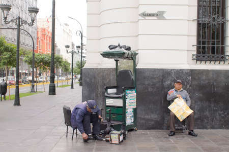 LIMA, PERU - AUG 29TH 2015: Man dedicated to the informal economy in the streets of downtown Lima, is dedicated to polishing shoes for peopleのeditorial素材
