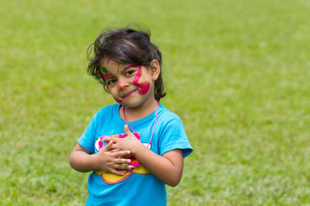 Little girl enjoys in the park with her face painted