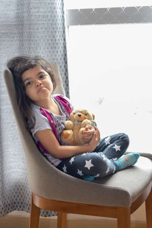 Cute little girl playing with her teddy bearの写真素材