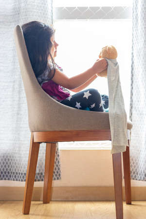 Cute little girl playing with her teddy bearの写真素材